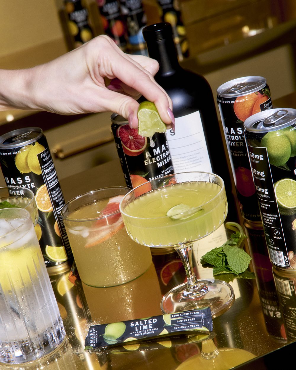 Cocktails made with AMASS Electrolyte Mixers on a gold bar