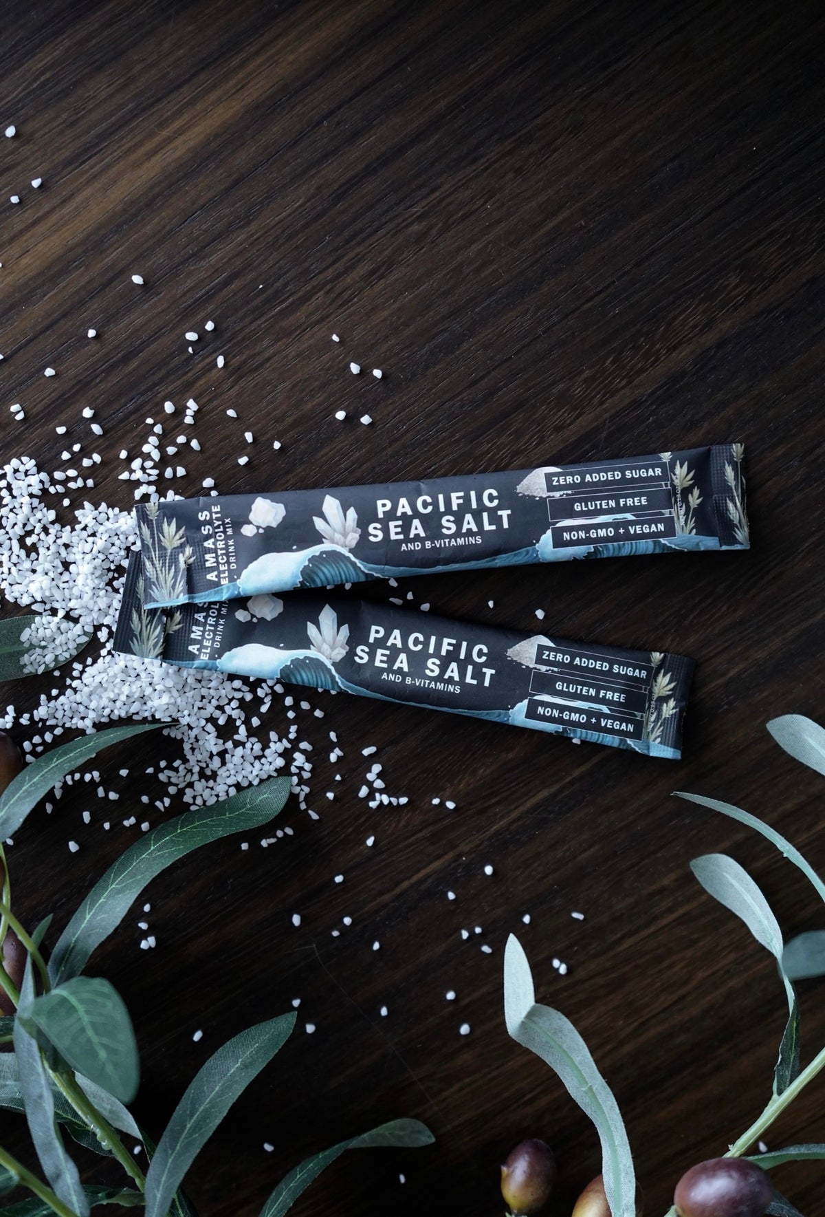 AMASS Pacific Sea Salt powder packets on dark walnut